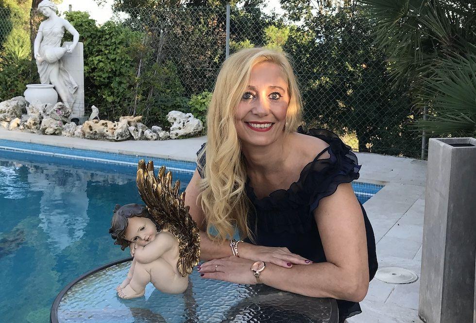 Esther López, holistic therapist and angelologist, next to an angel figure in Alella
