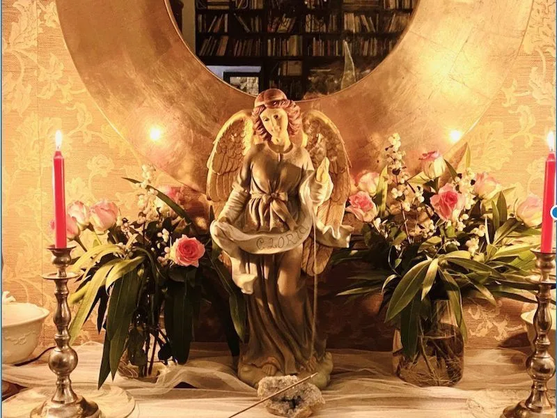 Altar de un portal de ángeles con figura de ángel, velas y flores